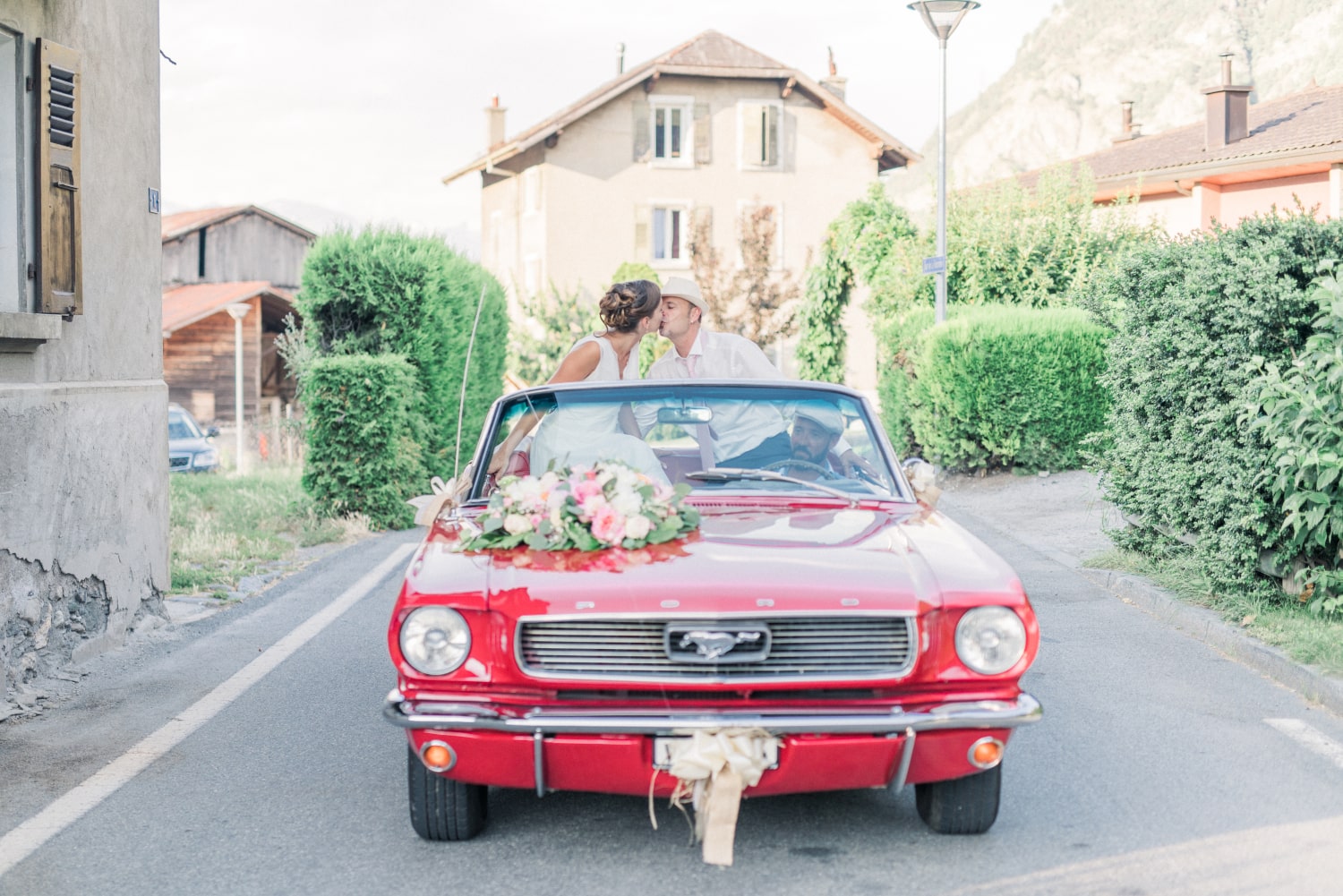 The newlyweds in a red Ford Mustang