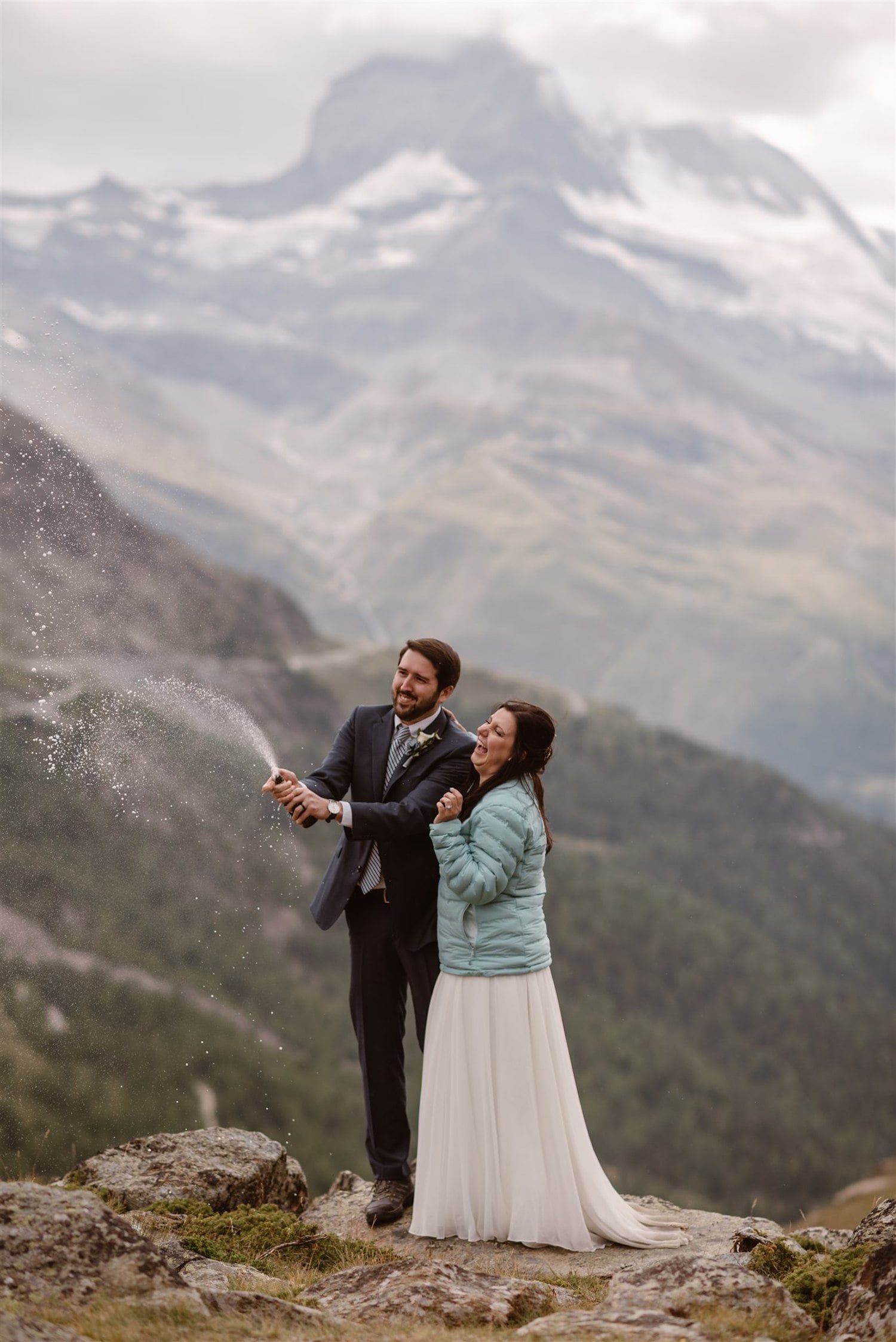 Newlyweds popping the Champagne during their summer elopement in Zermatt