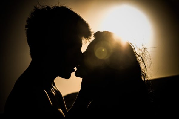 couple s'embrassant au coucher du soleil