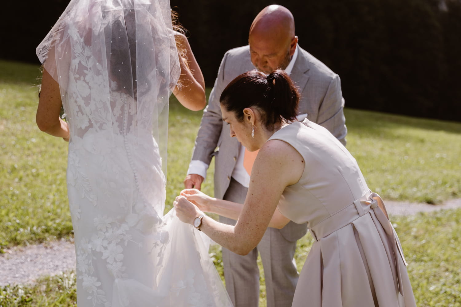 Celebrant adjusting bride's dress before ceremony
